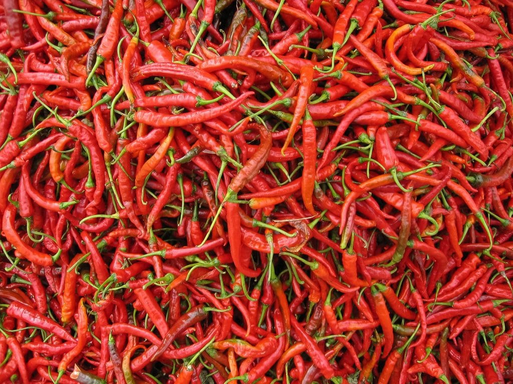 Grote stapel verse rode chilipepers op een markt in Dali, Yunnan, China