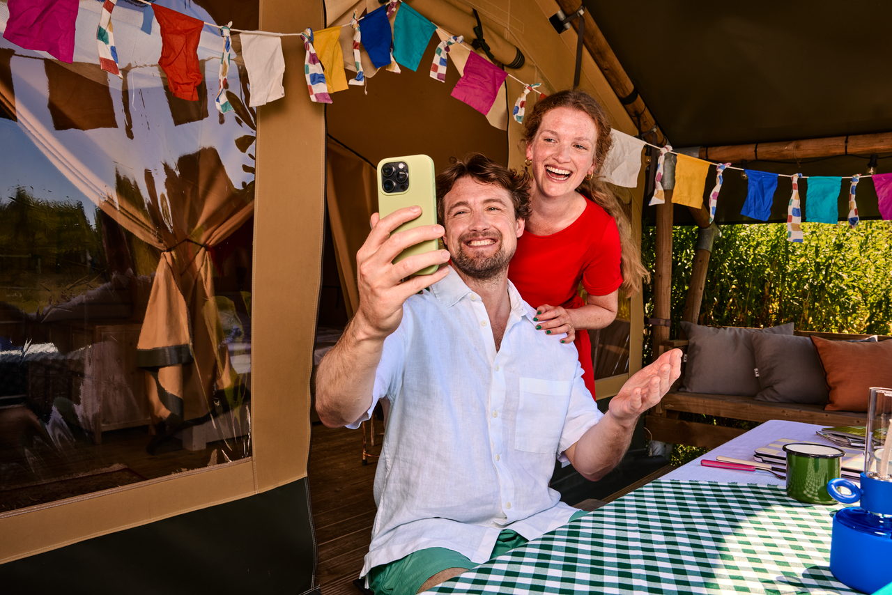 Man en vrouw voor een tent zijn aan het beeldbellen